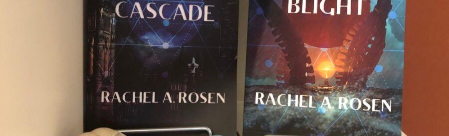 Two books, Cascade and Blight by Rachel A Rosen are propped up on a surface with bird skull and antifascist patch in foreground.